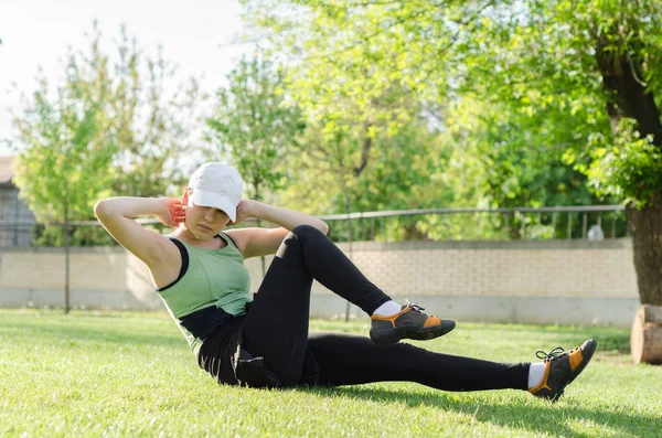 Mladá dívka s víčkem dělá cvičení — Stock fotografie