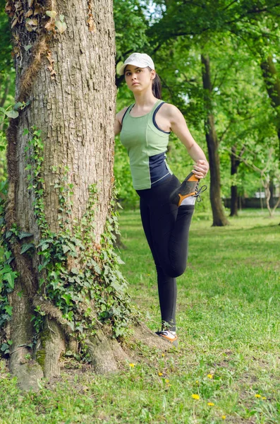 Девушка в кепке упражнения в парке — стоковое фото