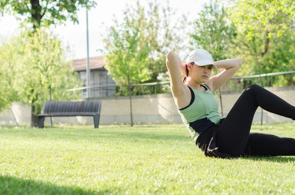 Jovem com um boné fazendo os exercícios — Fotografia de Stock