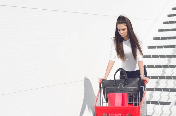 Kvinna poserar med shopping vagn — Stockfoto