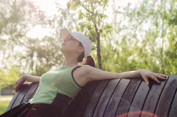 Chica joven en ropa deportiva con una gorra — Foto de Stock