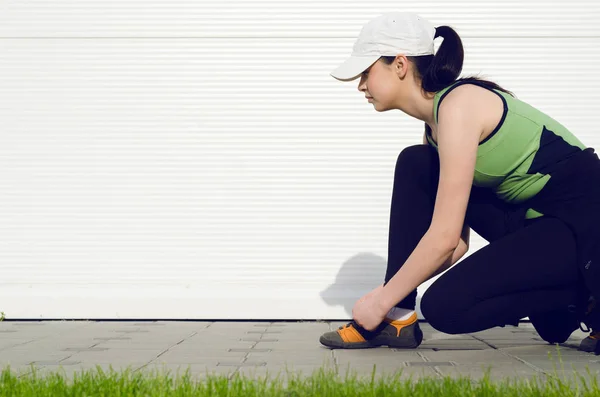 Mädchen bindet Schnürsenkel am Laufschuh — Stockfoto