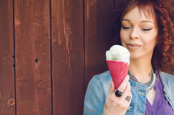 Chica en jeans chaqueta lamiendo helado — Foto de Stock