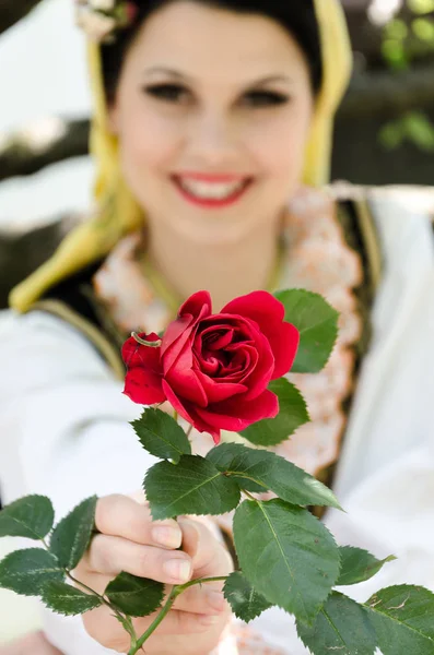 Lachende meisje geeft rose — Stockfoto
