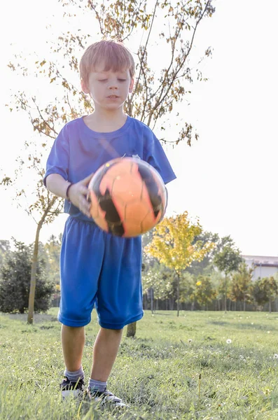 Kind zich voorbereidt op de schop de bal — Stockfoto