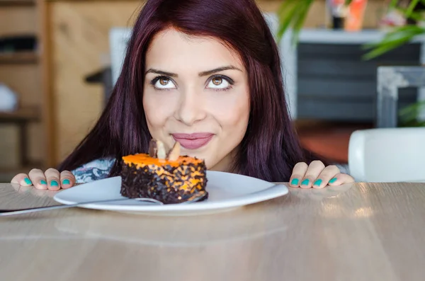 Mujer contemplando si comer pastel o no — Foto de Stock