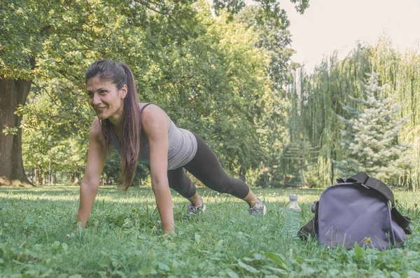 Młoda Kobieta Ćwiczenia Robi Deski Naturze — Zdjęcie stockowe