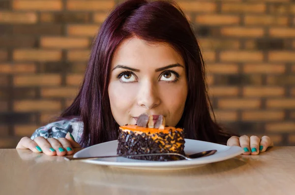 Mujer contemplando si comer pastel o no — Foto de Stock