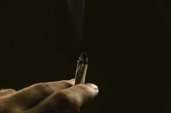 Manlig hand innehav cigarett — Stockfoto