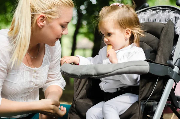Mor lopp med en baby i en barnvagn — Stockfoto