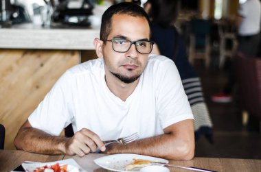 Adam restoranda yemek yiyor.