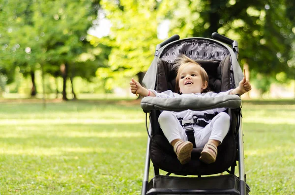 Baby flicka i en barnvagn — Stockfoto