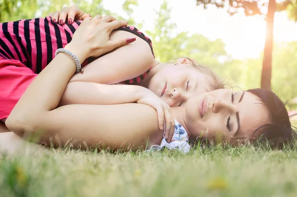 Мати і дочка лежать на траві — стокове фото