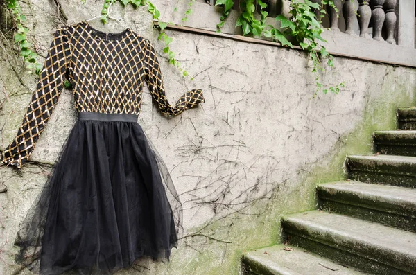 階段近くの壁にエレガントな黒のドレスのクローズ アップ — ストック写真