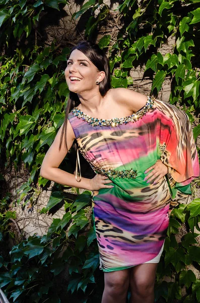 Усміхнена молода жінка в барвистій сукні — стокове фото