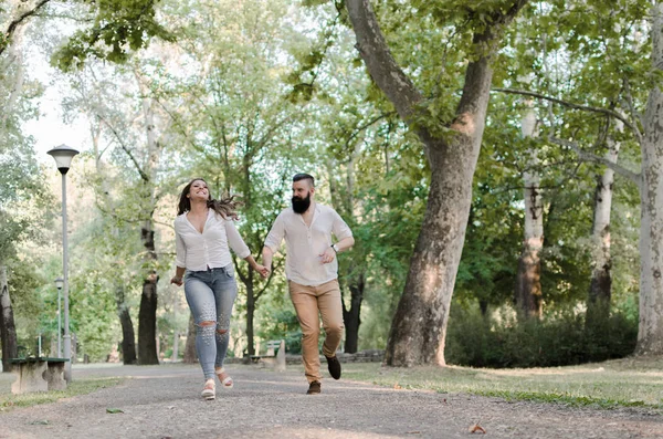 Homem e mulher correndo no parque e sorrindo — Fotografia de Stock