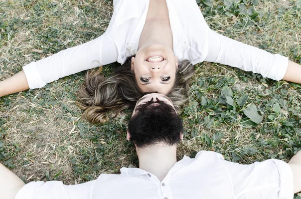 Вместе в любви мужчина и женщина лежат на траве — стоковое фото