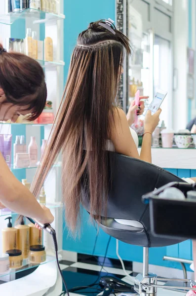 美发师在美容院梳理长时间损坏的女性头发 — 图库照片
