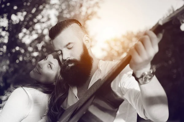 Beau couple relaxant avec guitare en plein air — Photo