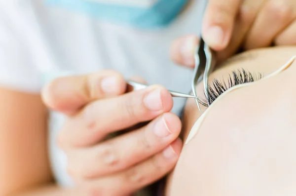 Woman in salon putting big eyelashes — Stock Photo, Image