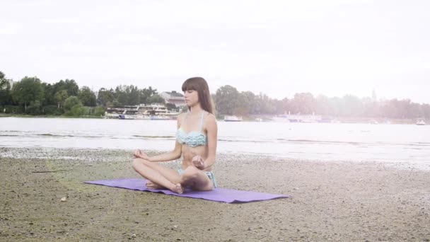 青い水着海海岸でヨガの練習で若い女性のクローズ アップ — ストック動画