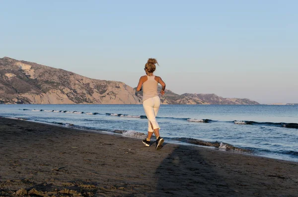 Γυμναστήριο Γυναίκα Που Τρέχει Στην Παραλία Βράδυ Και Ακούγοντας Μουσική — Φωτογραφία Αρχείου