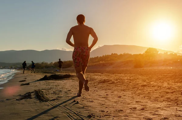 Man jogga på stranden solnedgången — Stockfoto