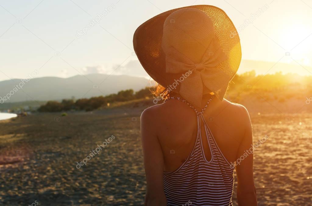 Back view of attractive woman with big hat