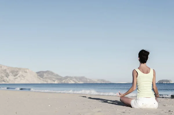 Yoga mujer joven meditando en la playa serena —  Fotos de Stock