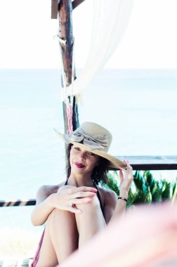 Sandalye üzerinde şapkalı kadın.