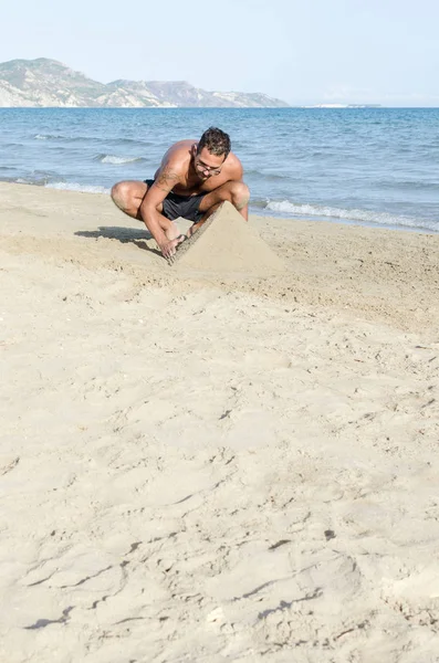 Mand gør pyramider af sand - Stock-foto