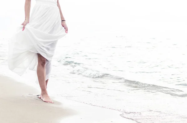 Frau geht am Strand spazieren — Stockfoto