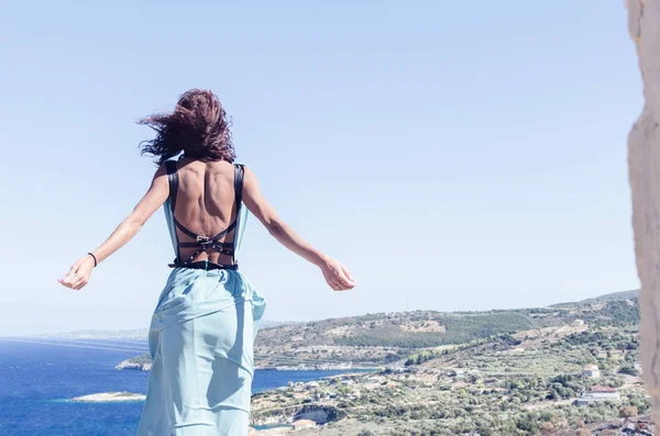 Vista posteriore della ragazza con alzare le mani sopra la città e il mare — Foto Stock