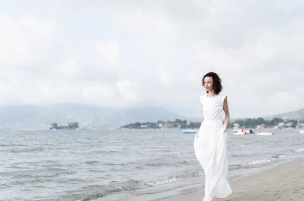 Hamile bir kadın sahilde yürüyor. — Stok fotoğraf