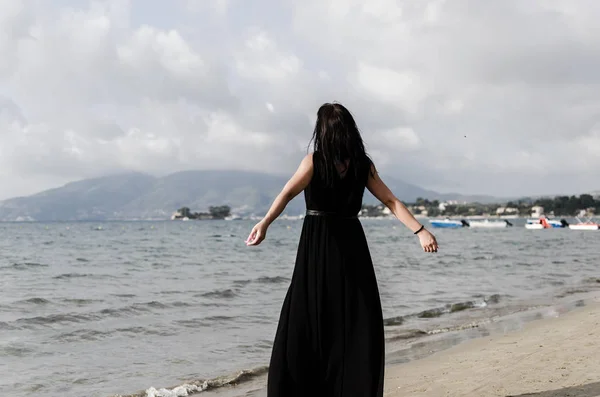 Zadní pohled žena v černém moři — Stock fotografie