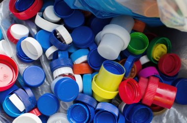 farklı renklerde plastik kapaklar büyük bir çanta içinde