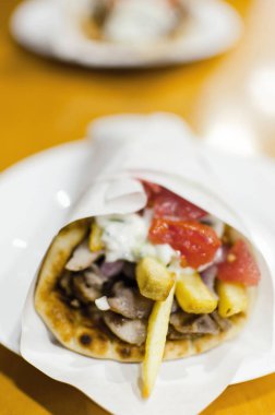 Dikey çekim Yunan kuzu eti gyros tzatziki sos, peynir ve patates kızartması ile