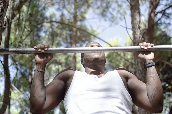 Černý muž dělá pull ups — Stock fotografie