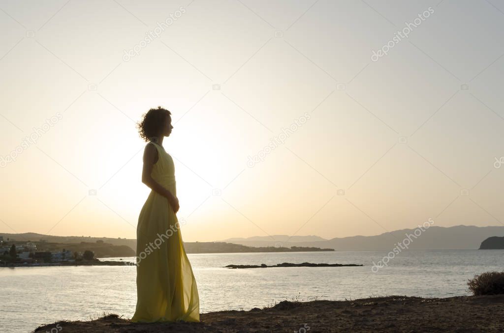 Dreamy woman waking on sea sunset