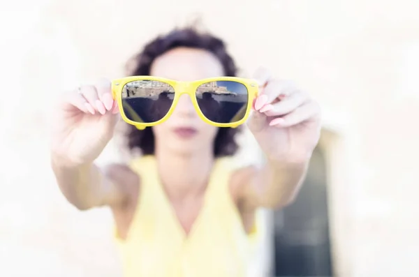 Женщина дает большие солнцезащитные очки для камеры — стоковое фото