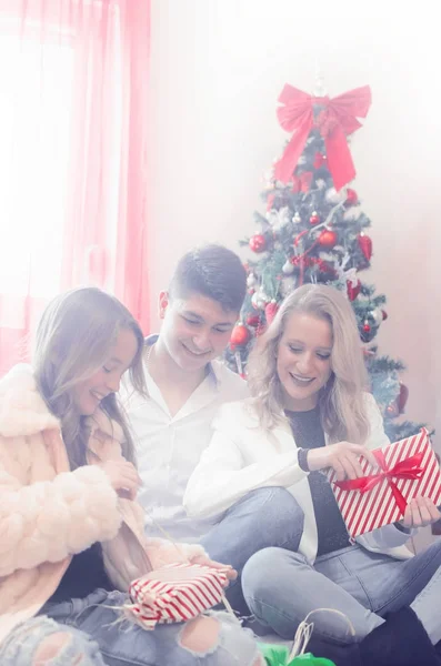 Счастливая молодая семья празднует Рождество — стоковое фото