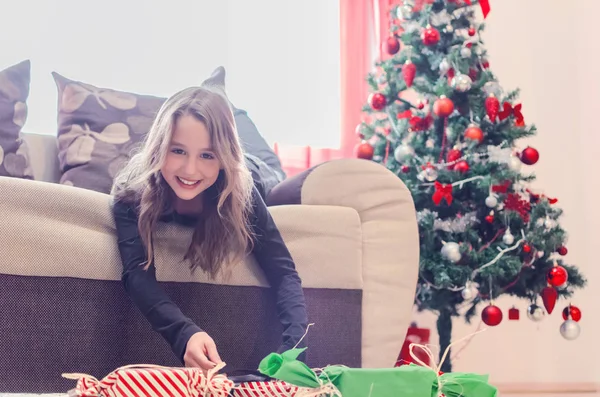 Молодая девушка открывает рождественский подарок — стоковое фото