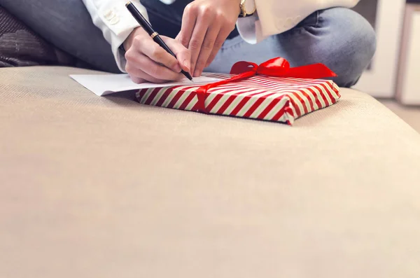 Jonge vrouw schrijft een verlanglijstje — Stockfoto