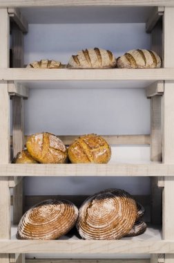 Variety of delicious breads displayed on shelves in bakery clipart