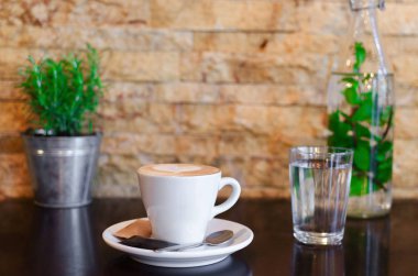bir bardak su üzerinde ahşap bir masa ile espresso fincan