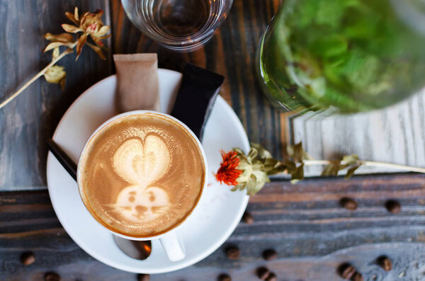 Latte art, coffee art made by barista on beautiful retro wooden background, view from above or top. Копирование текста
