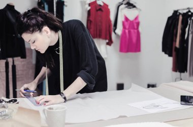 Studio terzi dükkanında çalışan kadın moda tasarımcısı