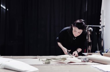 profesyonel kadın terzi makas ve taslak tasarım karton üzerinde kumaş malzeme kullanarak Close-Up