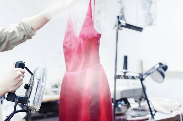 Manos Mujer Sosteniendo Hierro Caliente Vestido Rojo Vapor Salón Limpieza — Foto de Stock