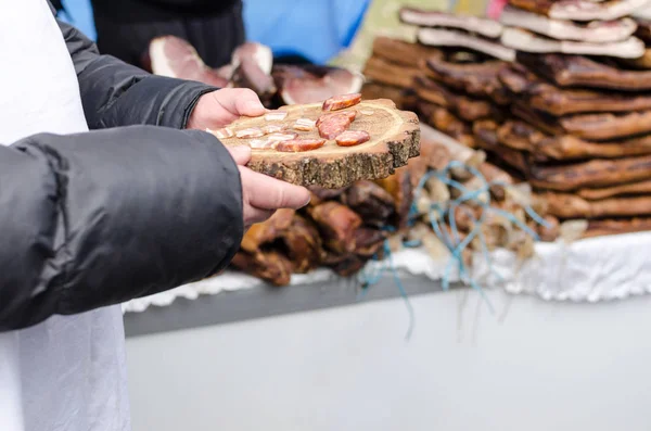 Aşağıdaki metin sokak, alan üzerinde domuz pastırması parçaları tutan el